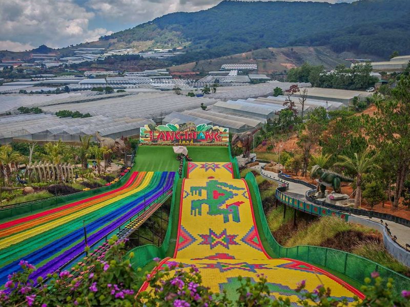 Rainbow slide attraction at Langbiang Land with colorful lanes and dinosaur-themed park near Dalat