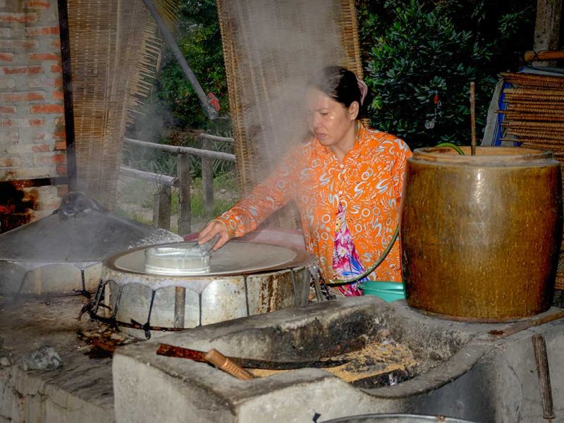 Rice paper steaming process demonstrated by a craftswoman in rural Can Tho