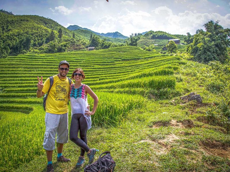A couple is making a romantic trekking in Sapa through the rice fields while on their honeymoon in Vietnam