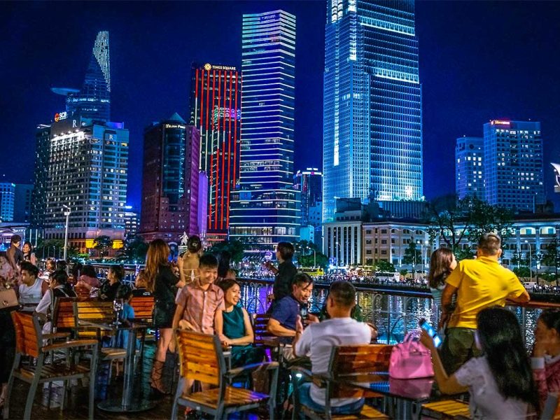 People enjoying the skyline of Ho Chi Minh City from a dinner cruise on the Saigon River