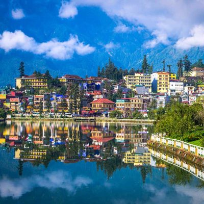 Sapa Town with Mountain Backdrop: Sapa town nestles in a valley with a picturesque lake and majestic mountains rising in the background.