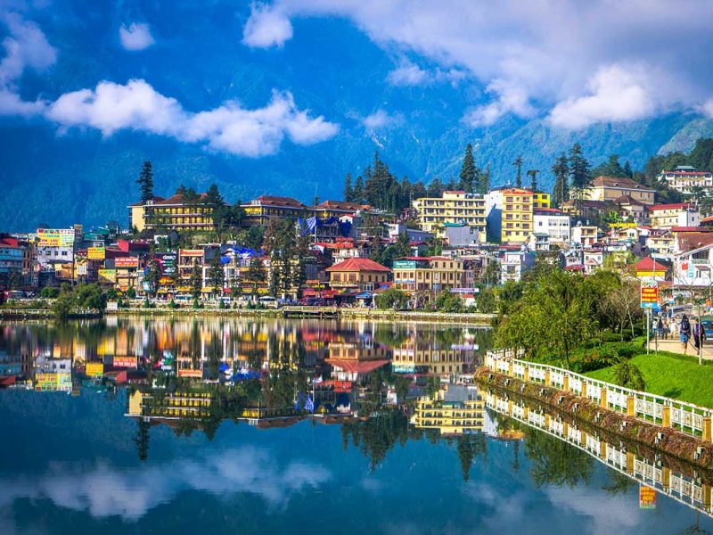 Sapa Town with Mountain Backdrop: Sapa town nestles in a valley with a picturesque lake and majestic mountains rising in the background.
