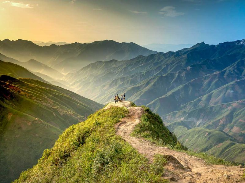 Dinosaur Spine of Ta Xua - A dirt path leading over the edge of the mountain with valley views on a clear day without clouds