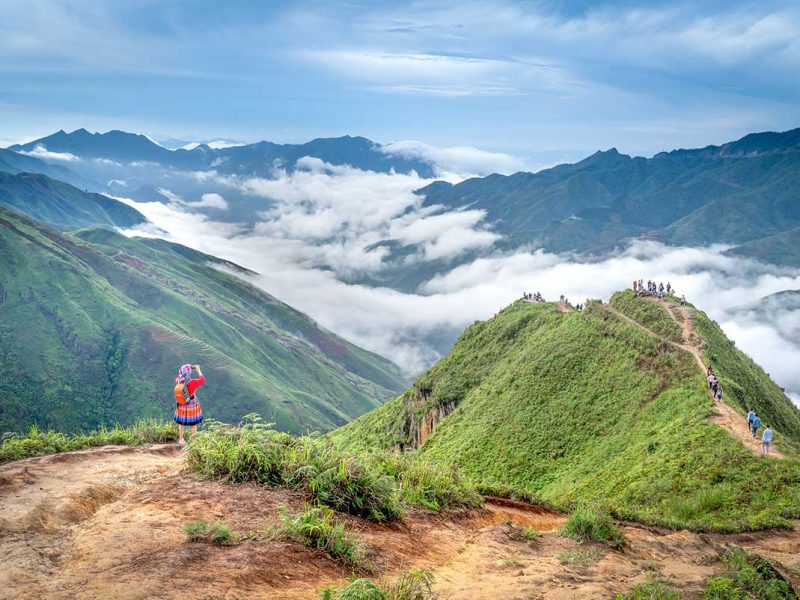 A person trekking over the ridge of a mountain nicknamed Dinosaur Spine in Ta Xua