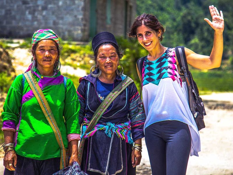 A tourist woman doing a trekking in Sapa and meets two ethnic minority woman