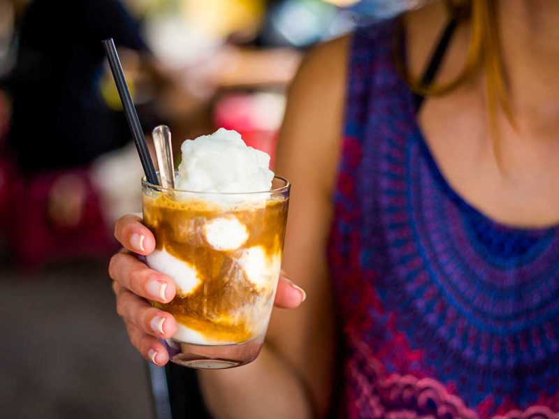 A woman holding a Vietnamese coconut coffee